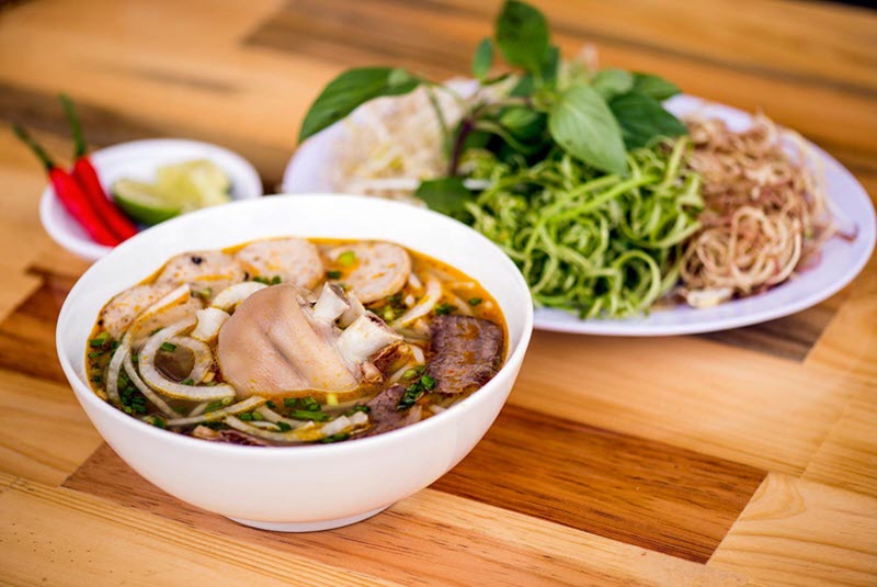 Bún bò Bảo Lộc với topping đầy đủ như chả giò, chả cua, bắp hoa bò, và nạm bò