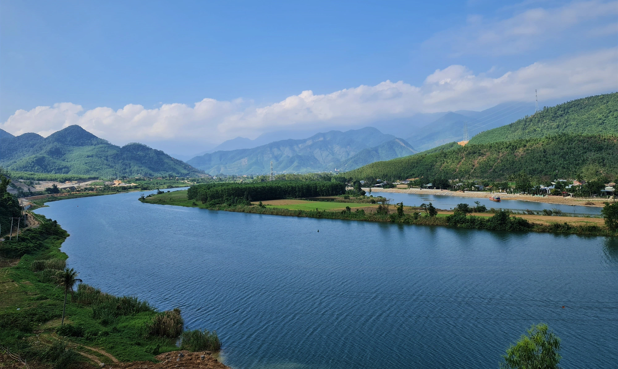 Dòng sông uốn lượn giữa núi đồi, chấm phá là những bãi bồi, ruộng nương của người dân